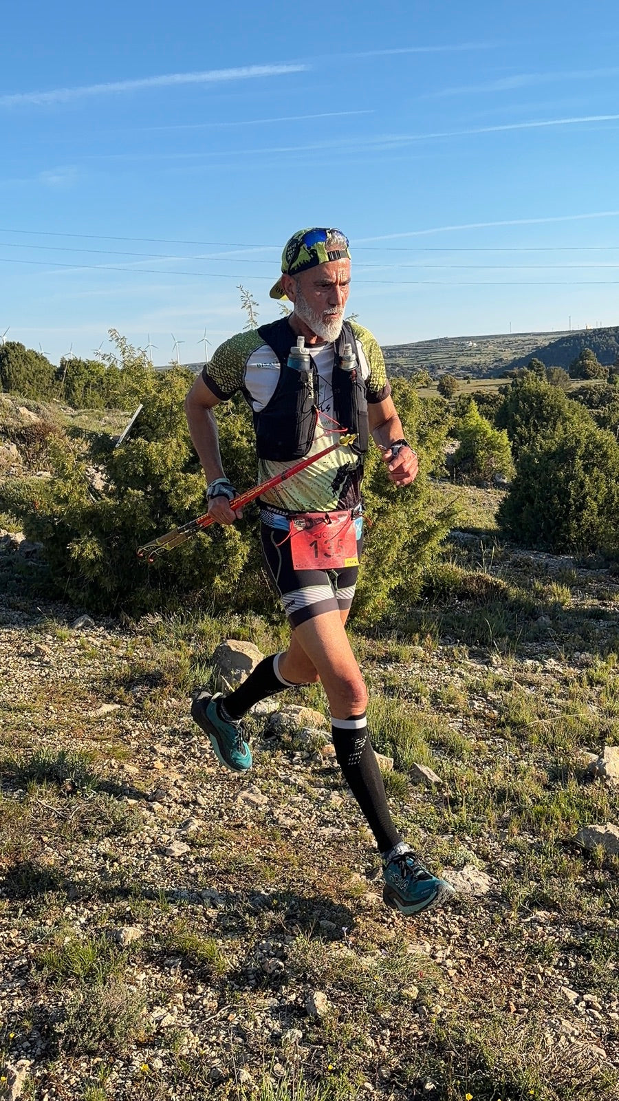 Corredor de trail con chaleco en plena carrera por la montaña