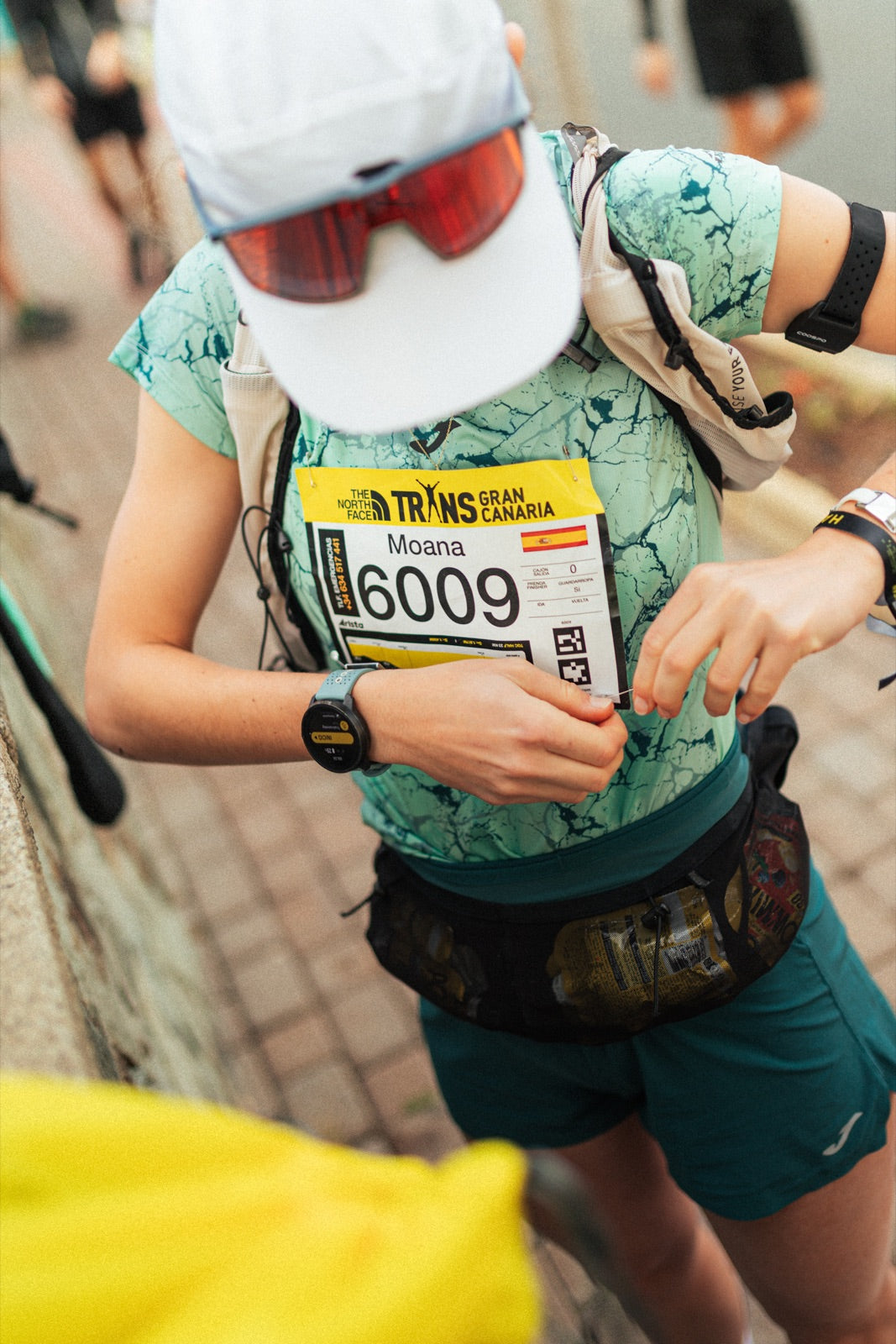 Corredor con dorsal tomando un gel POWMIX en carrera