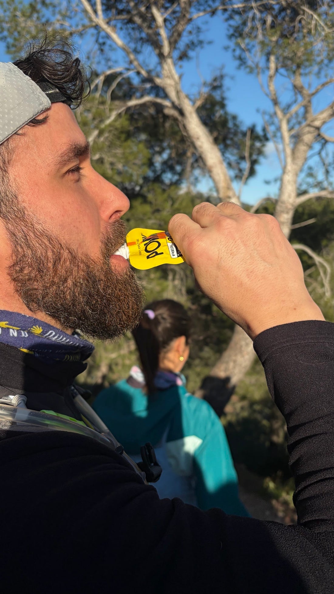 Corredor tomando un gel POWMIX en una salida por el bosque