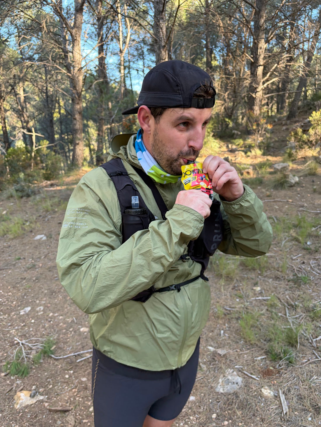 Corredor de trail tomando un gel POWMIX directamente del envase